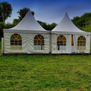 Two big white tents for events in the woods on a festival meadow